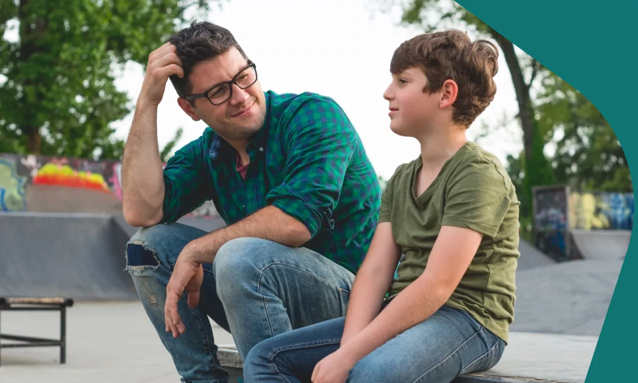 Photo: Father and child sitting in park